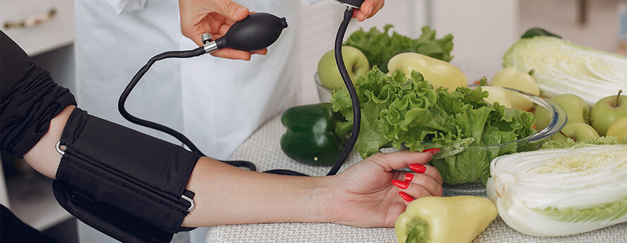 Doctor Measuring Blood Pressure Near Healthy Vegetables