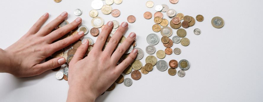 Person Counting Pound And Penny Coins On A Table Saving Money